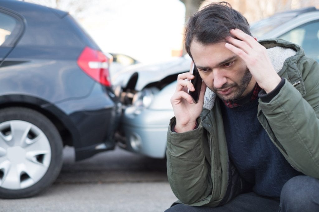 Man on phone after car accident.